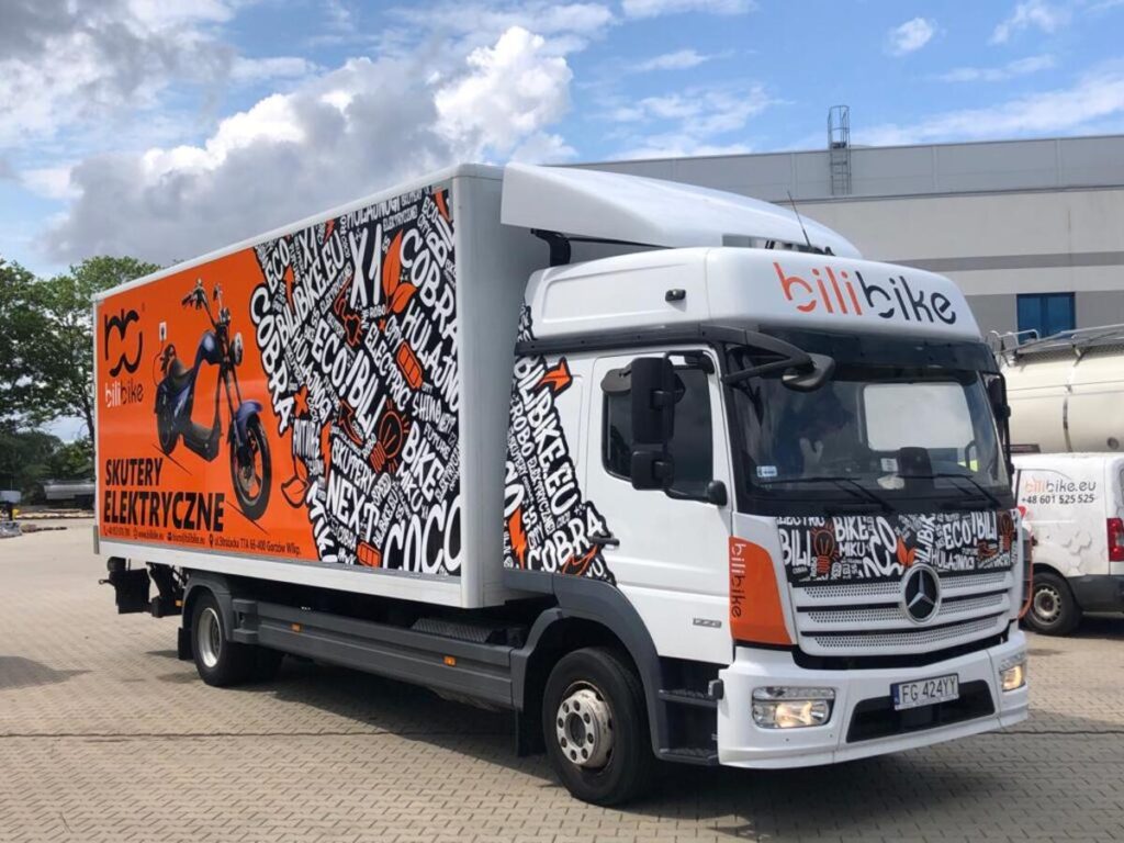 Ciężarówka z pełną grafiką reklamową wykonaną metodą oklejania