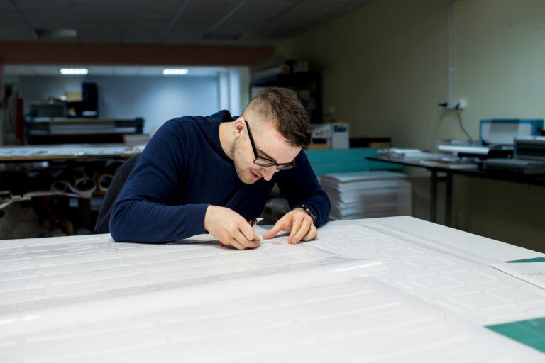 Pracownik wykonujący precyzyjne oznaczenia i kontrolę jakości wydruku